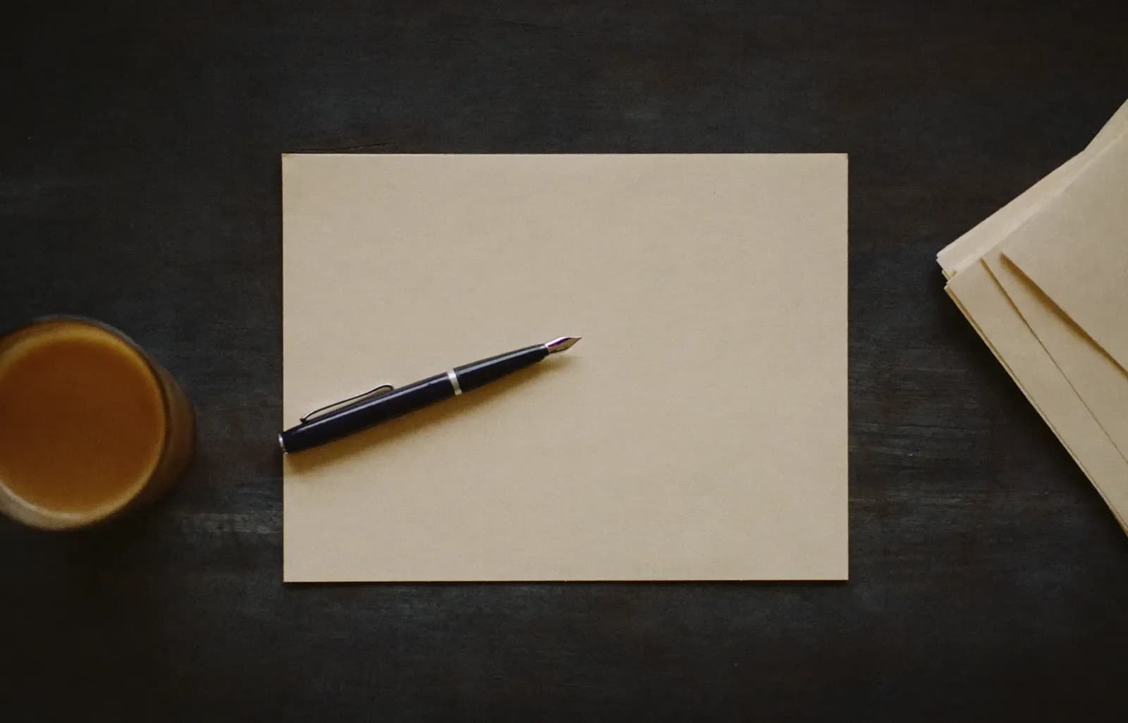 A blank form, a pen and a glass of tea on a desk